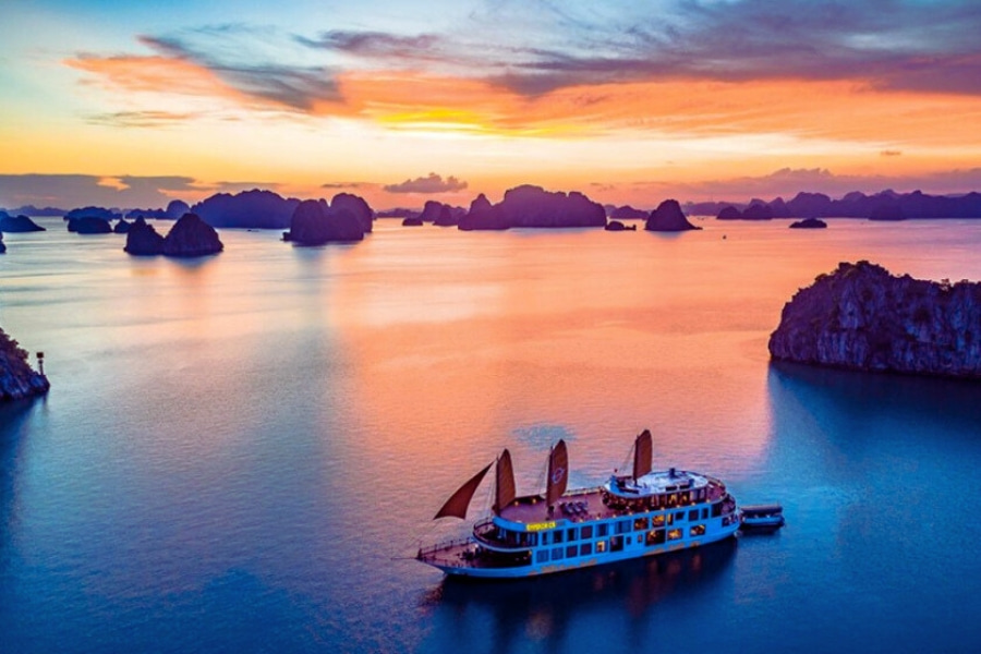 Halong Bay luxury cruise with traditional sails at colorful sunset &ndash; Auasia Travel